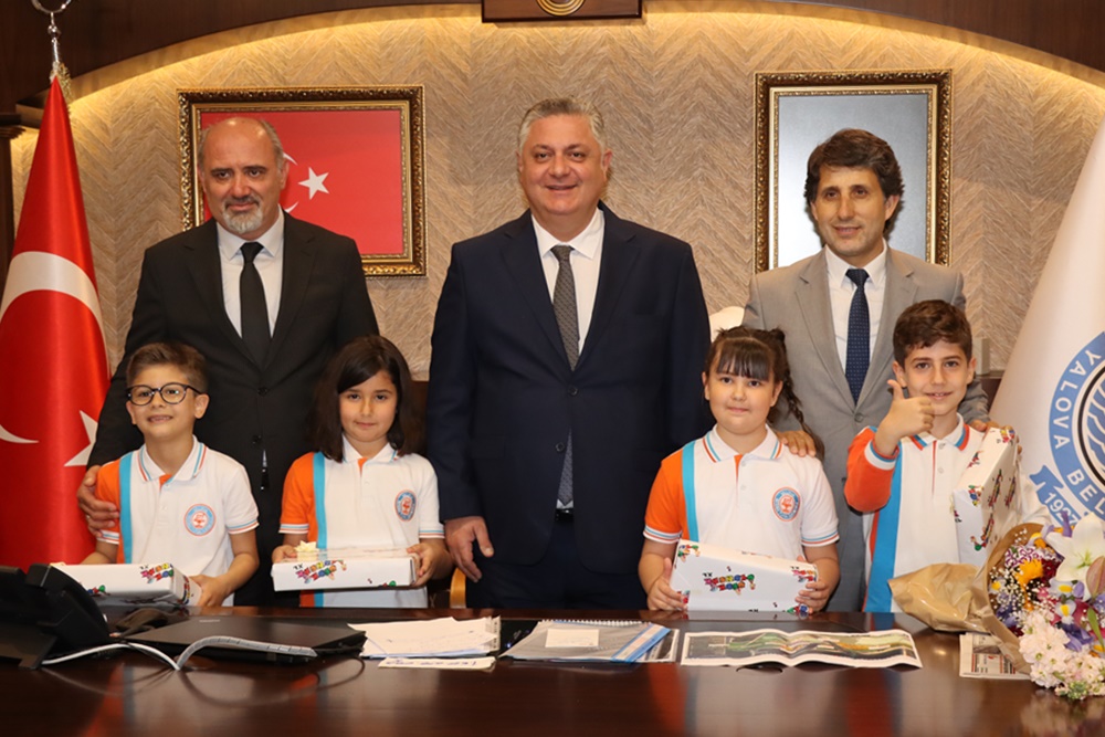 GÜREL KOLTUĞUNU 4 İLKOKUL ÖĞRENCİSİNE TESLİM ETTİ