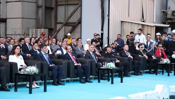 Formal event with seated dignitaries.